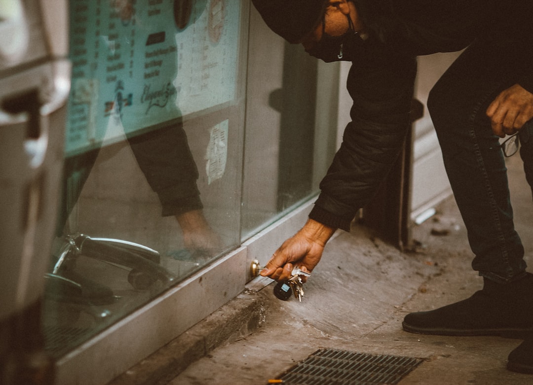 person in black jacket holding black and silver hand tool